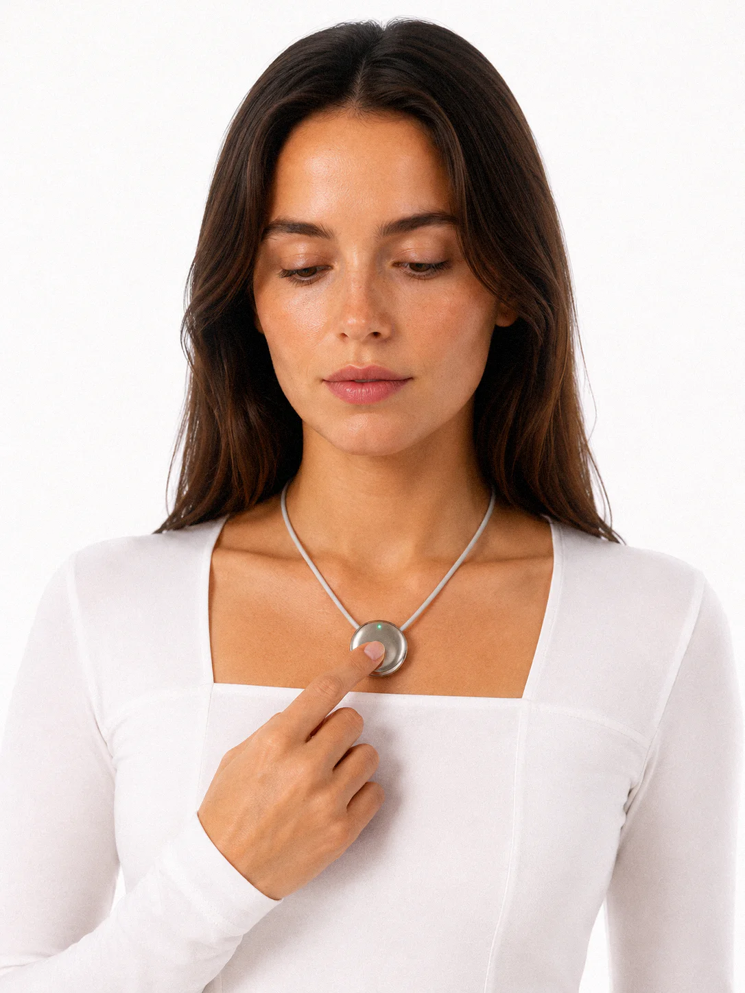 A woman wearing the Pebb pendant, touching it to start speaking